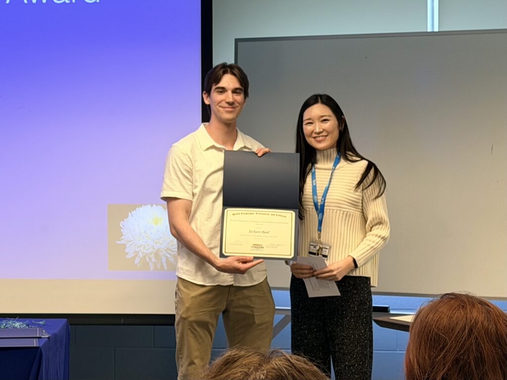 Student receiving the WLLC Enrichment Award in Japanese while standing with a faculty presenter.