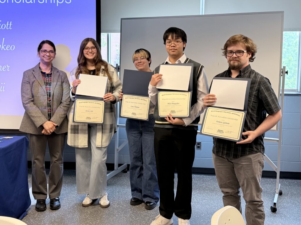 Group of students holding certificates as recipients of the Kiyoshi Kawahito Scholarship alongside a faculty member.